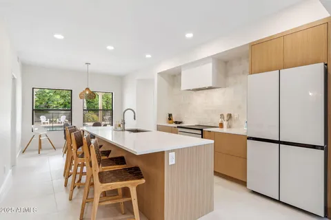 a kitchen with a table chairs refrigerator and microwave