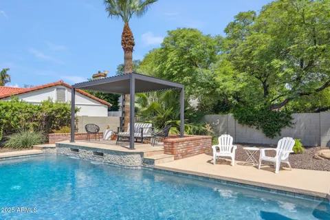 a view of pool table and chairs under an umbrella