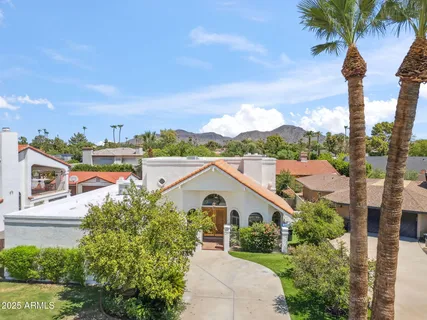 a view of a house with a yard and potted plants