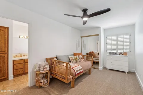 a bed room with a bed and a ceiling fan