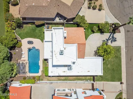 an aerial view of a house with a yard and pool