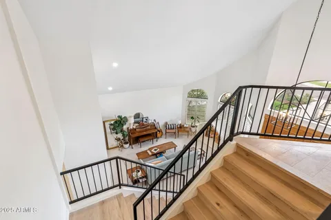 a view of staircase with lots of frames on wall and a window