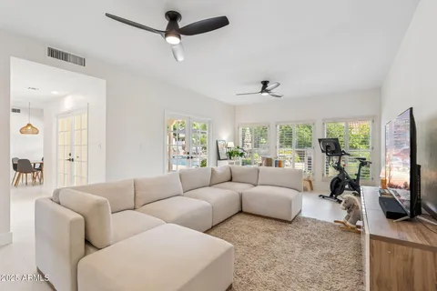 a living room with furniture a flat screen tv and a large window