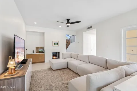 a living room with furniture flat screen tv and a window
