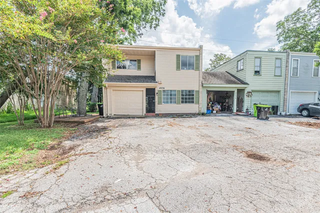 a view of a white house with a yard