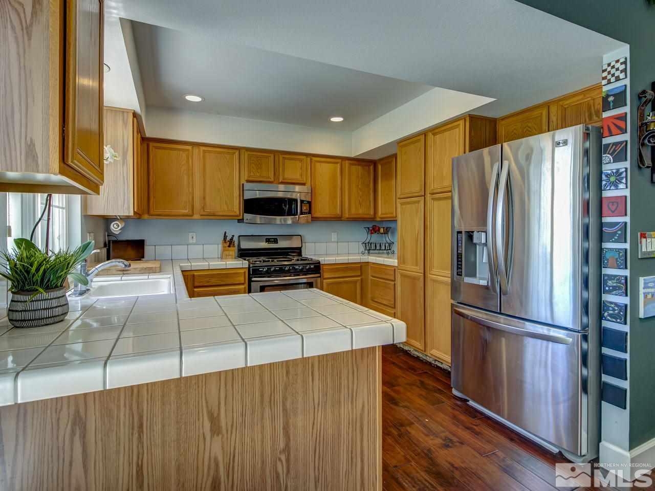 14410 Ghost Rider Drive Reno, NV 89511 - Photo 11 of 25 a kitchen with granite countertop a refrigerator and a sink