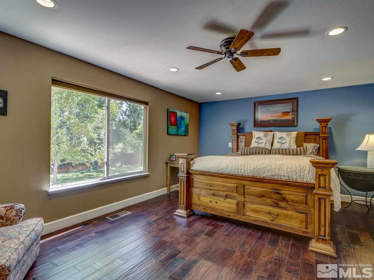 14410 Ghost Rider Drive Reno, NV 89511 - Photo 13 of 25 a bedroom with a bed and wooden floor