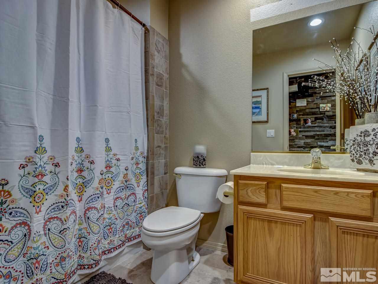 14410 Ghost Rider Drive Reno, NV 89511 - Photo 18 of 25 a bathroom with a granite countertop sink and a toilet