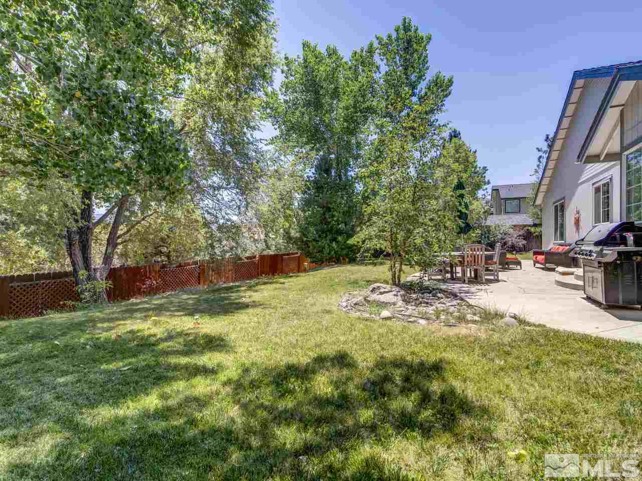 14410 Ghost Rider Drive Reno, NV 89511 - Photo 20 of 25 a view of a yard with table and chairs and a large tree