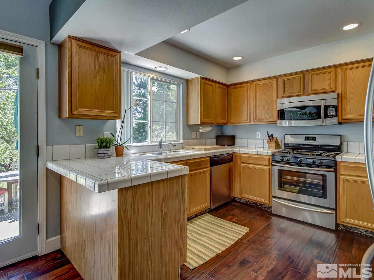 14410 Ghost Rider Drive Reno, NV 89511 - Photo 10 of 25 a kitchen with stainless steel appliances granite countertop a stove a sink and a microwave