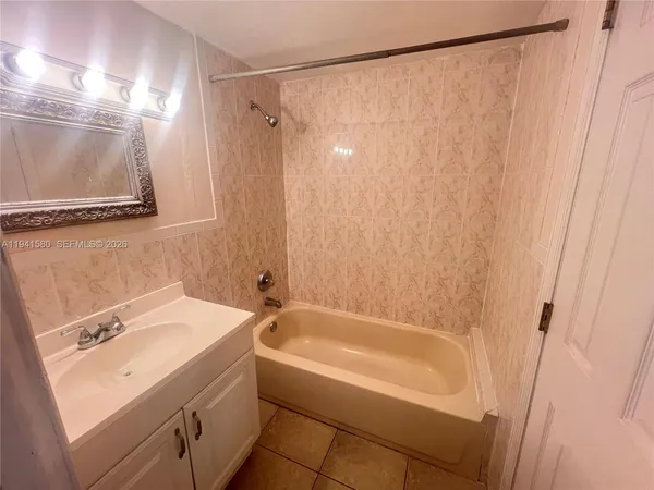 a bathroom with a sink a mirror a shower and a bathtub