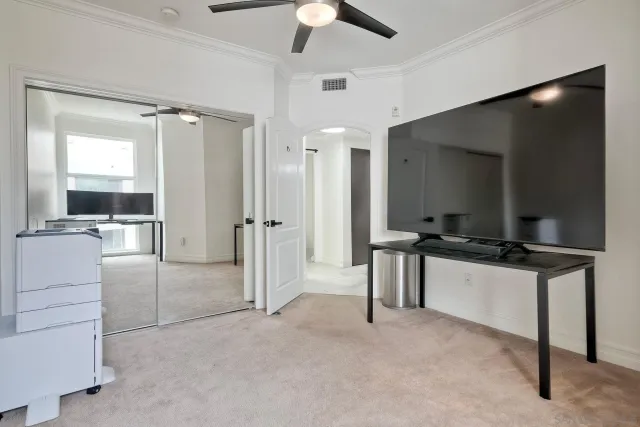 a living room with a flat screen tv and white walls