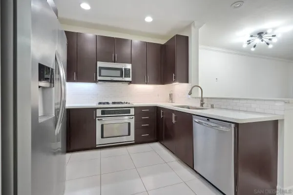 a kitchen with stainless steel appliances granite countertop a sink and a stove top oven