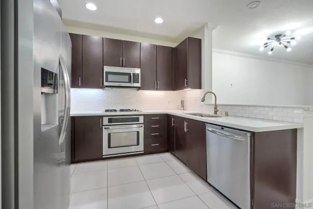 a kitchen with stainless steel appliances granite countertop a sink and a stove top oven