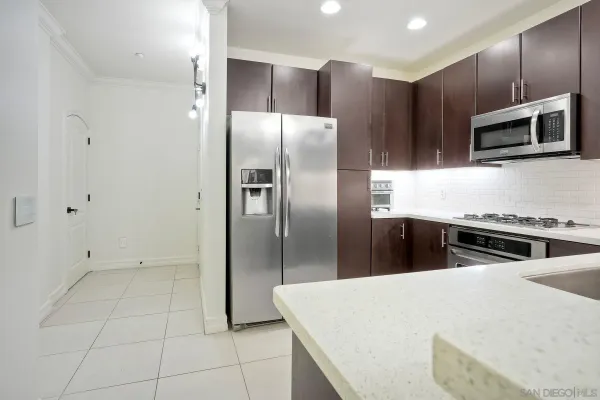 a kitchen with stainless steel appliances granite countertop a refrigerator and a stove