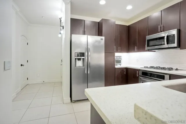 a kitchen with stainless steel appliances granite countertop a refrigerator and a stove