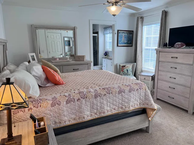 a bedroom with a bed and a flat tv screen on dresser