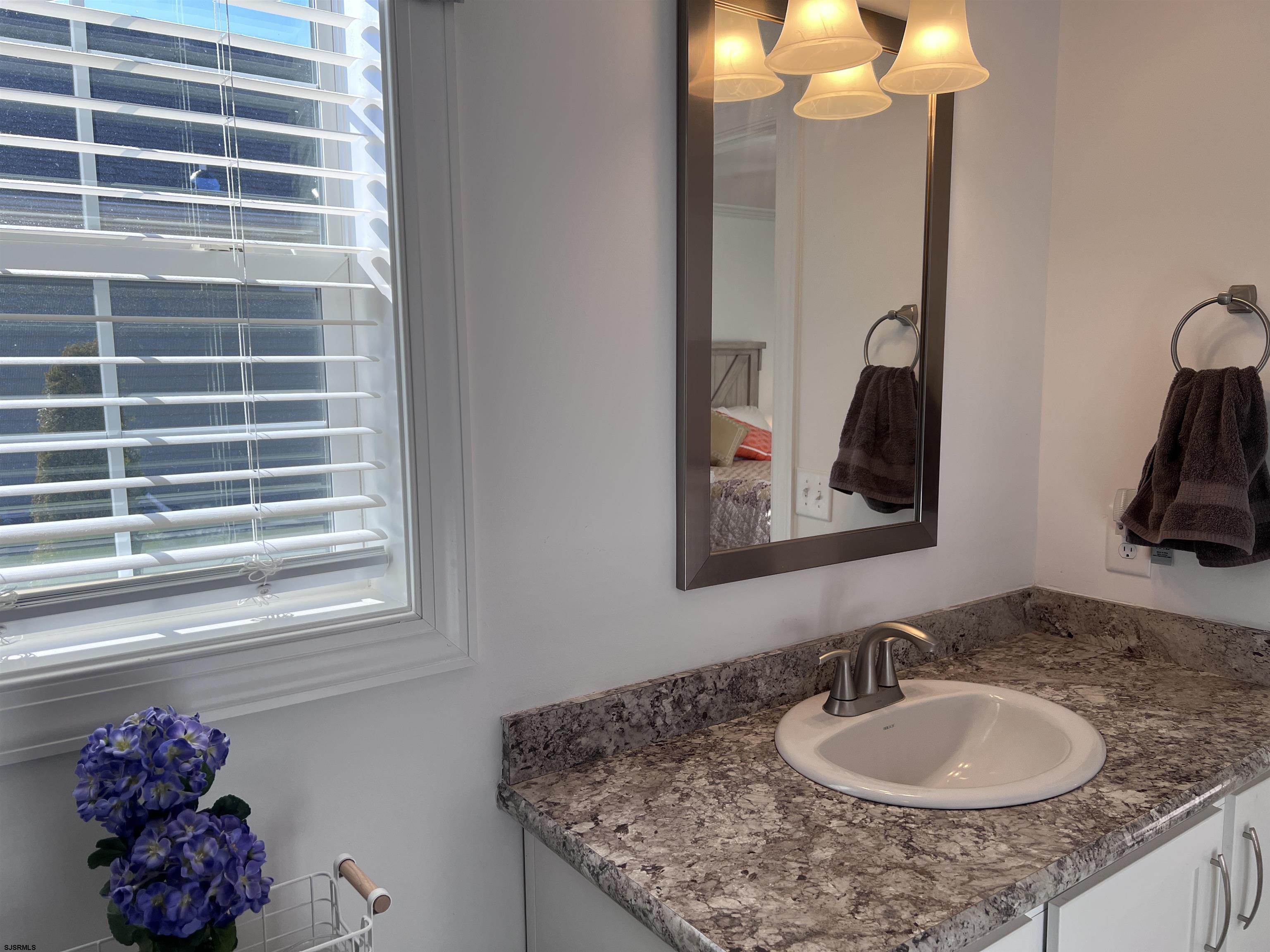 2058 Highway 9 Ocean View, NJ 08230 - Photo 21 of 37 a bathroom with a granite countertop sink a large mirror and a window