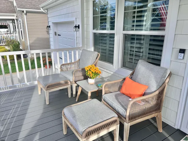 an outdoor sitting area with chairs and wooden floor
