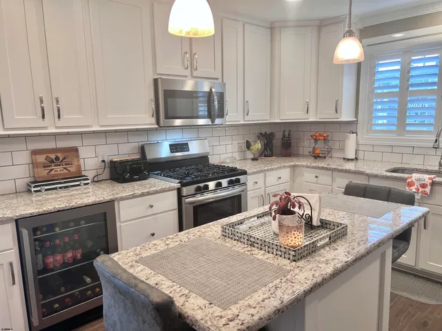 a kitchen with granite countertop a sink a stove and cabinets