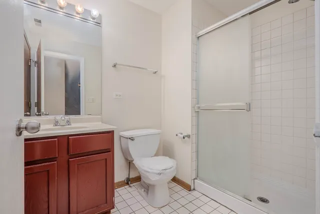 a bathroom with a granite countertop sink toilet a mirror and shower