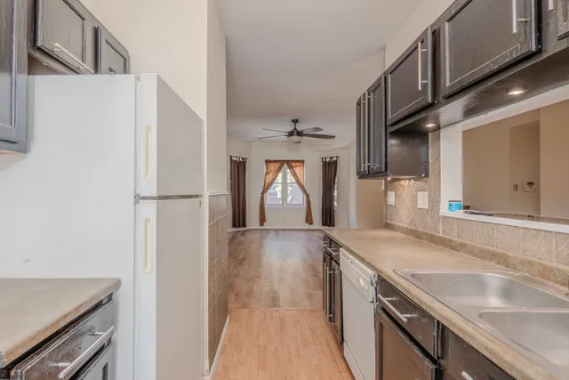 a kitchen with granite countertop a sink and a refrigerator