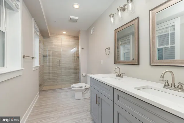a bathroom with a double vanity sink toilet and shower