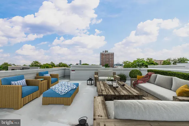 an outdoor living room with patio furniture and a table