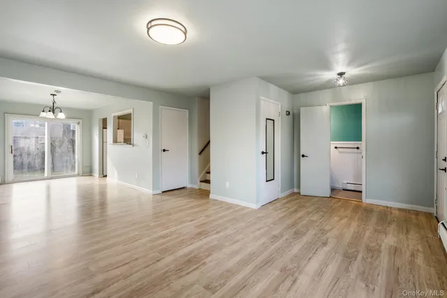 a view of an empty room with window and wooden floor