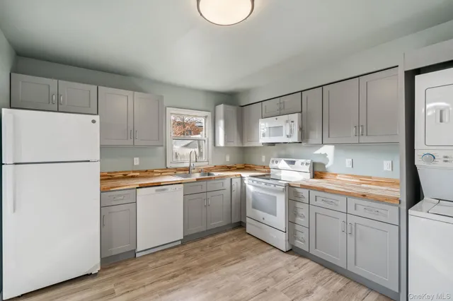 a kitchen with stainless steel appliances granite countertop a refrigerator sink and white cabinets
