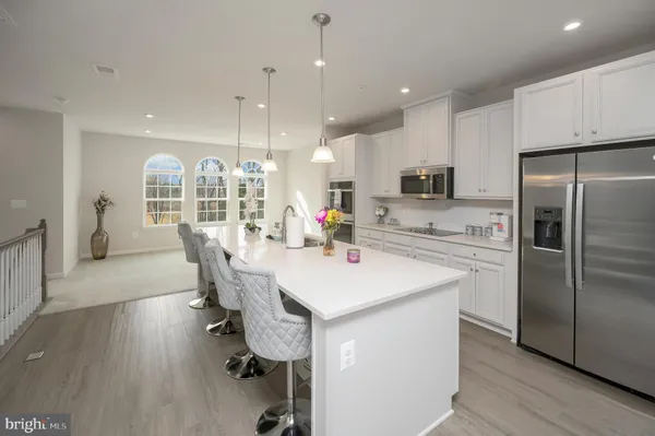 a kitchen with kitchen island a stove a table and chairs