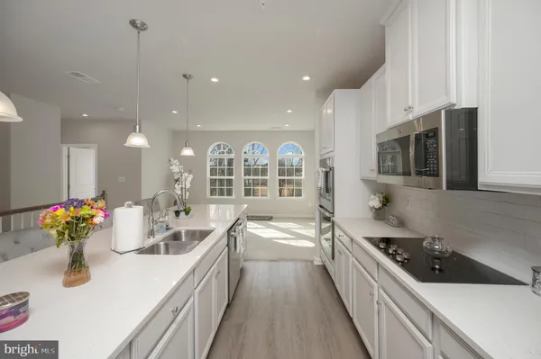 a kitchen with stainless steel appliances kitchen island granite countertop a sink stove and cabinets