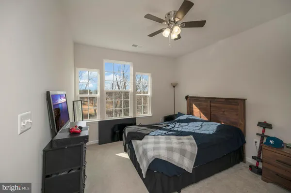 a bedroom with a bed flat screen tv and a window