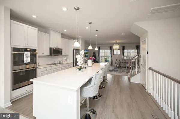 a large white kitchen with lots of counter space a sink and appliances