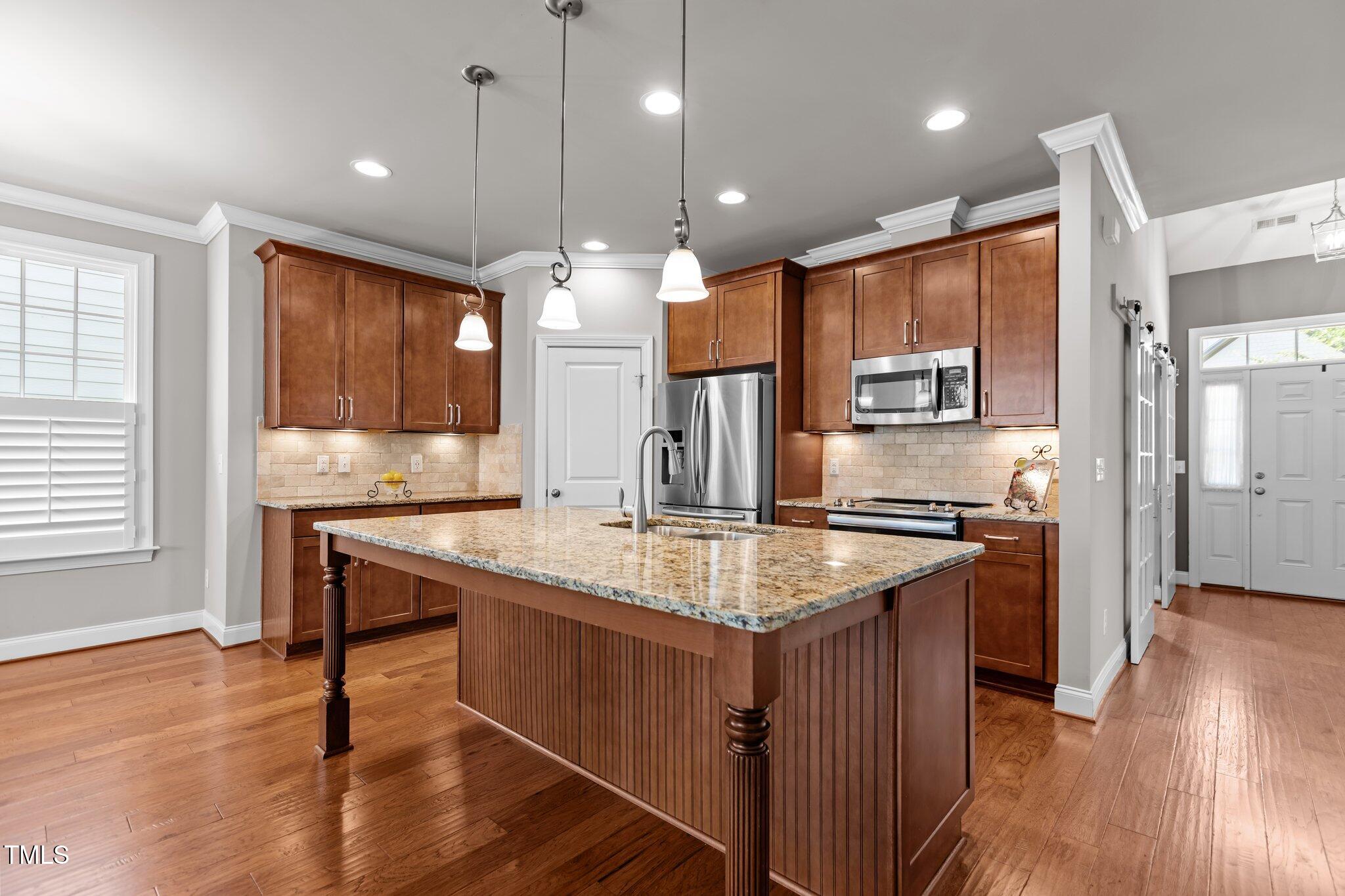 511 Mill Hopper Lane Apex, NC 27502 - Photo 12 of 53 a kitchen with stainless steel appliances granite countertop a sink stove and wooden floor