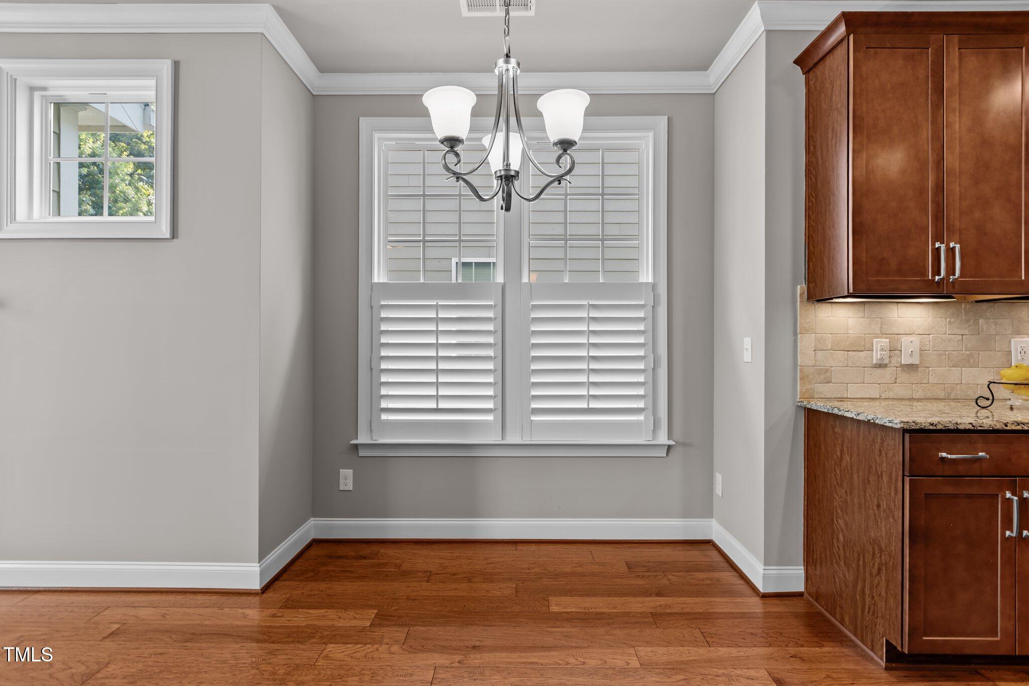 511 Mill Hopper Lane Apex, NC 27502 - Photo 13 of 53 a view of an empty room with window and wooden floor