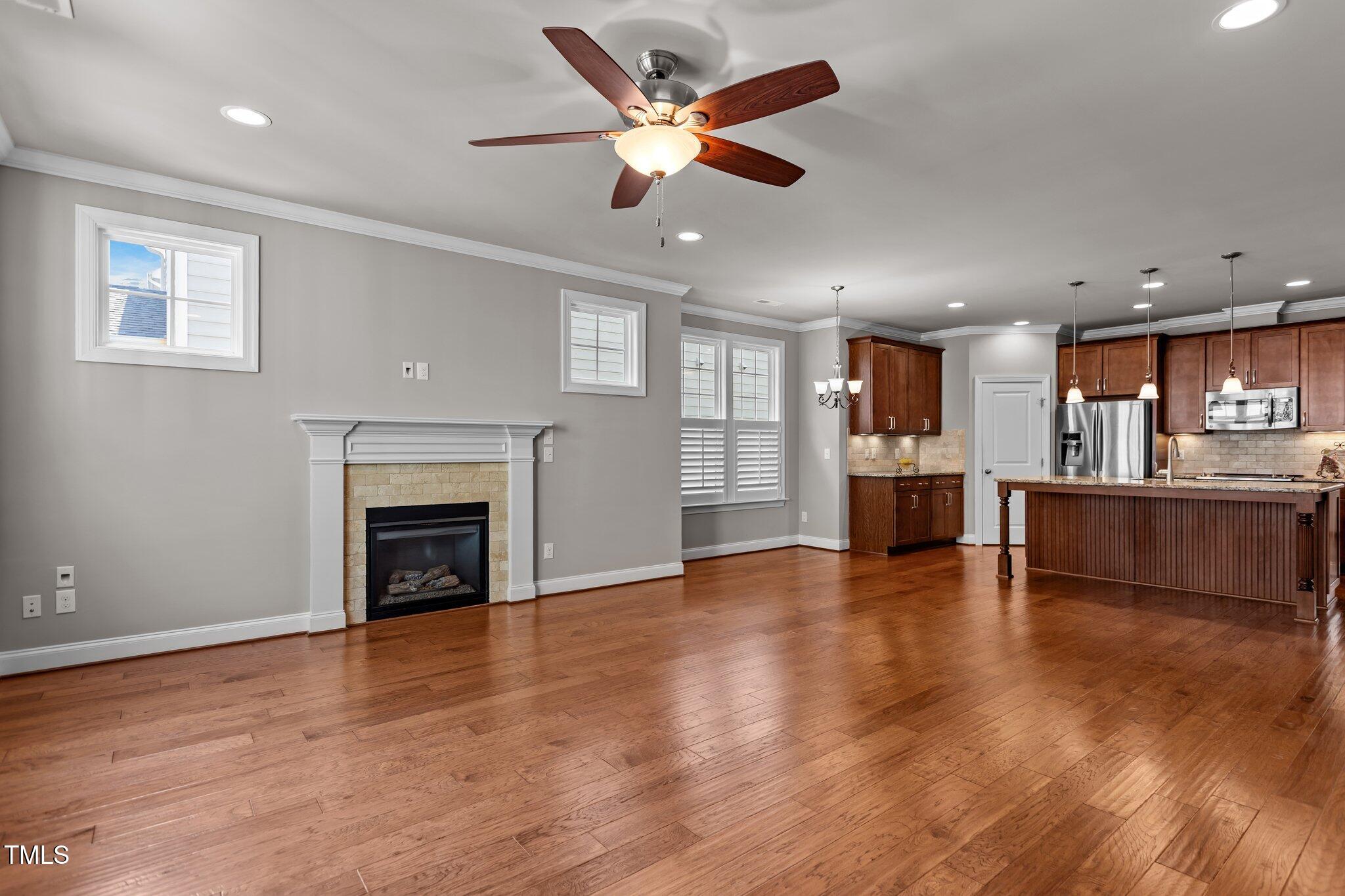 511 Mill Hopper Lane Apex, NC 27502 - Photo 16 of 53 a view of an empty room with wooden floor and a kitchen