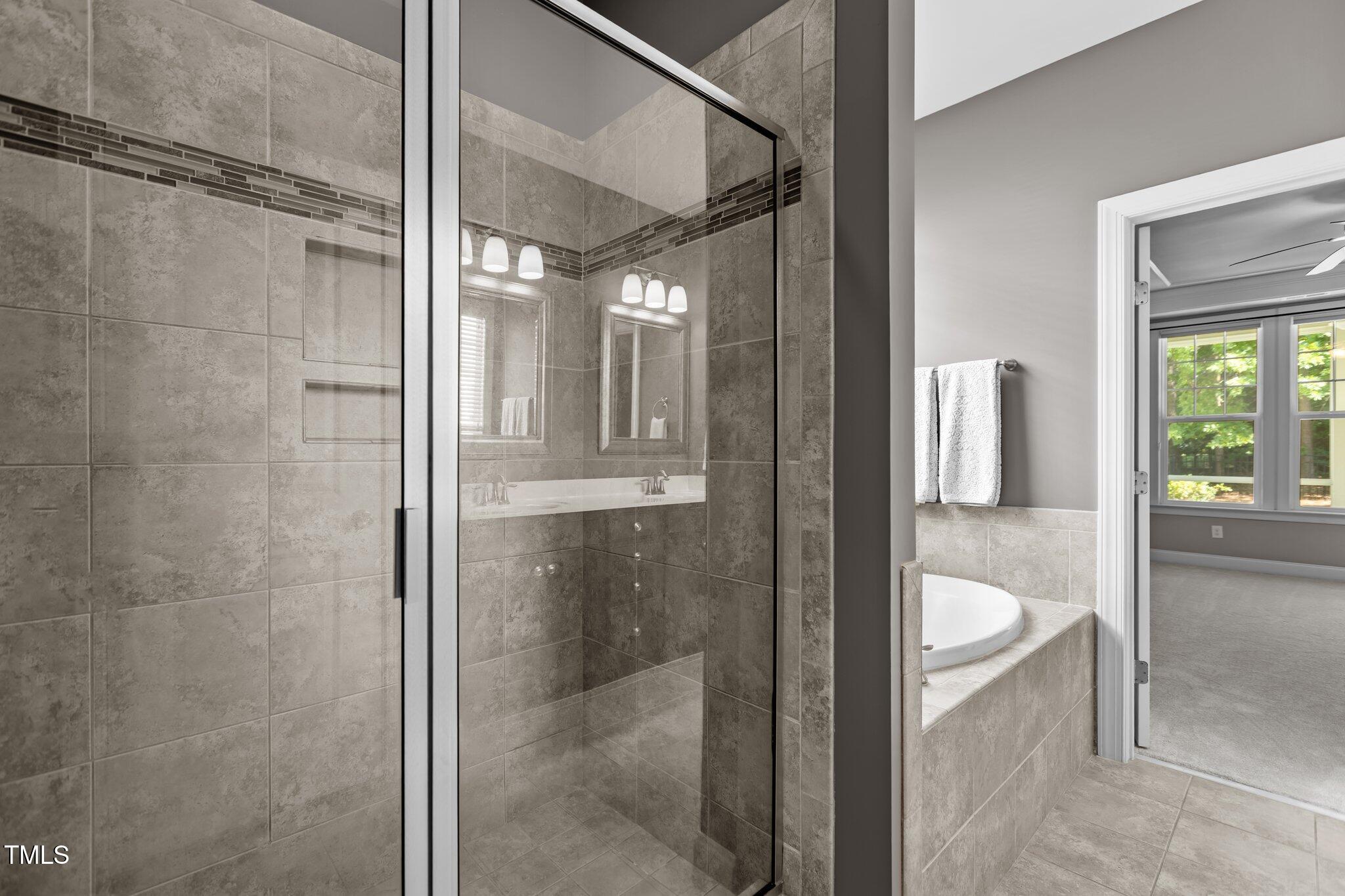 511 Mill Hopper Lane Apex, NC 27502 - Photo 25 of 53 a bathroom with a bathtub and shower