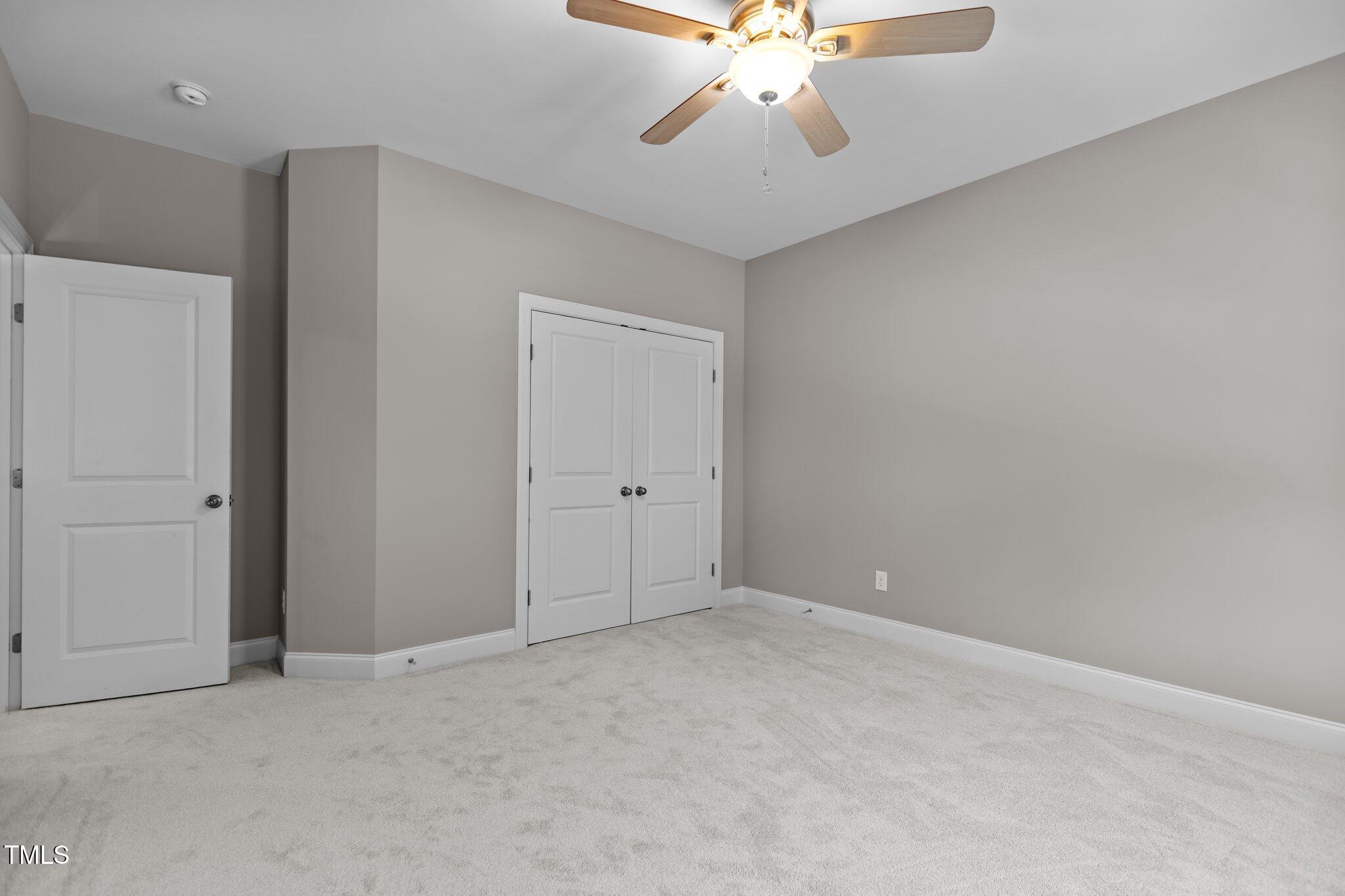 511 Mill Hopper Lane Apex, NC 27502 - Photo 37 of 53 a view of an empty room with a chandelier fan