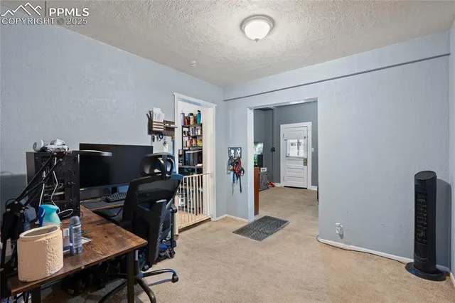 a view of a workspace with furniture and a window