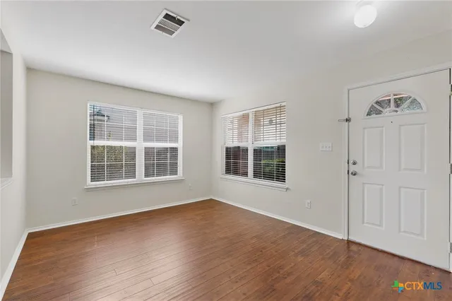 a view of wooden floor and windows in an empty room