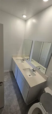 a bathroom with a sink mirror vanity and toilet