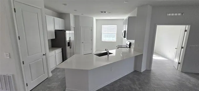 a hallway with wooden floor and cabinet