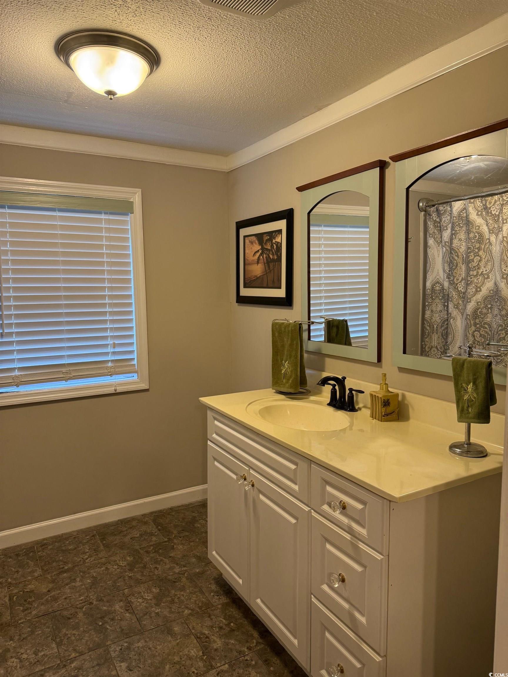 2709 Orion Drive Myrtle Beach, SC 29575 - Photo 21 of 27 Full bathroom featuring vanity, a textured ceiling, a shower with curtain, and crown molding