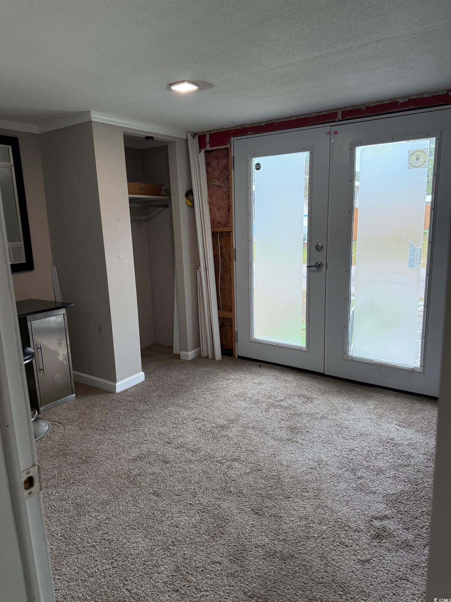 2709 Orion Drive Myrtle Beach, SC 29575 - Photo 23 of 27 Unfurnished bedroom featuring french doors, light colored carpet, a textured ceiling, a closet, and access to outside