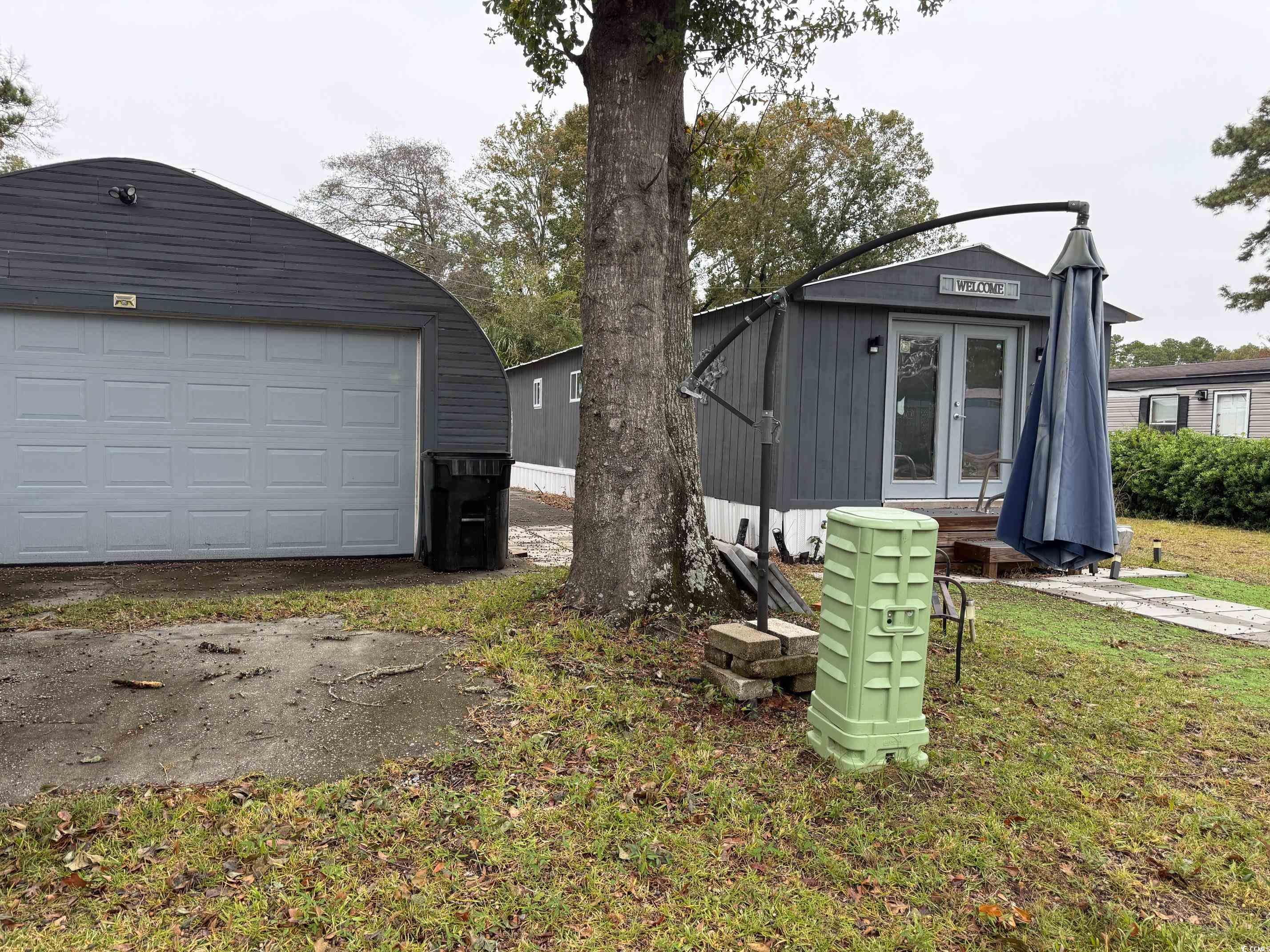 2709 Orion Drive Myrtle Beach, SC 29575 - Photo 5 of 27 View of green lawn featuring an outdoor structure and french doors