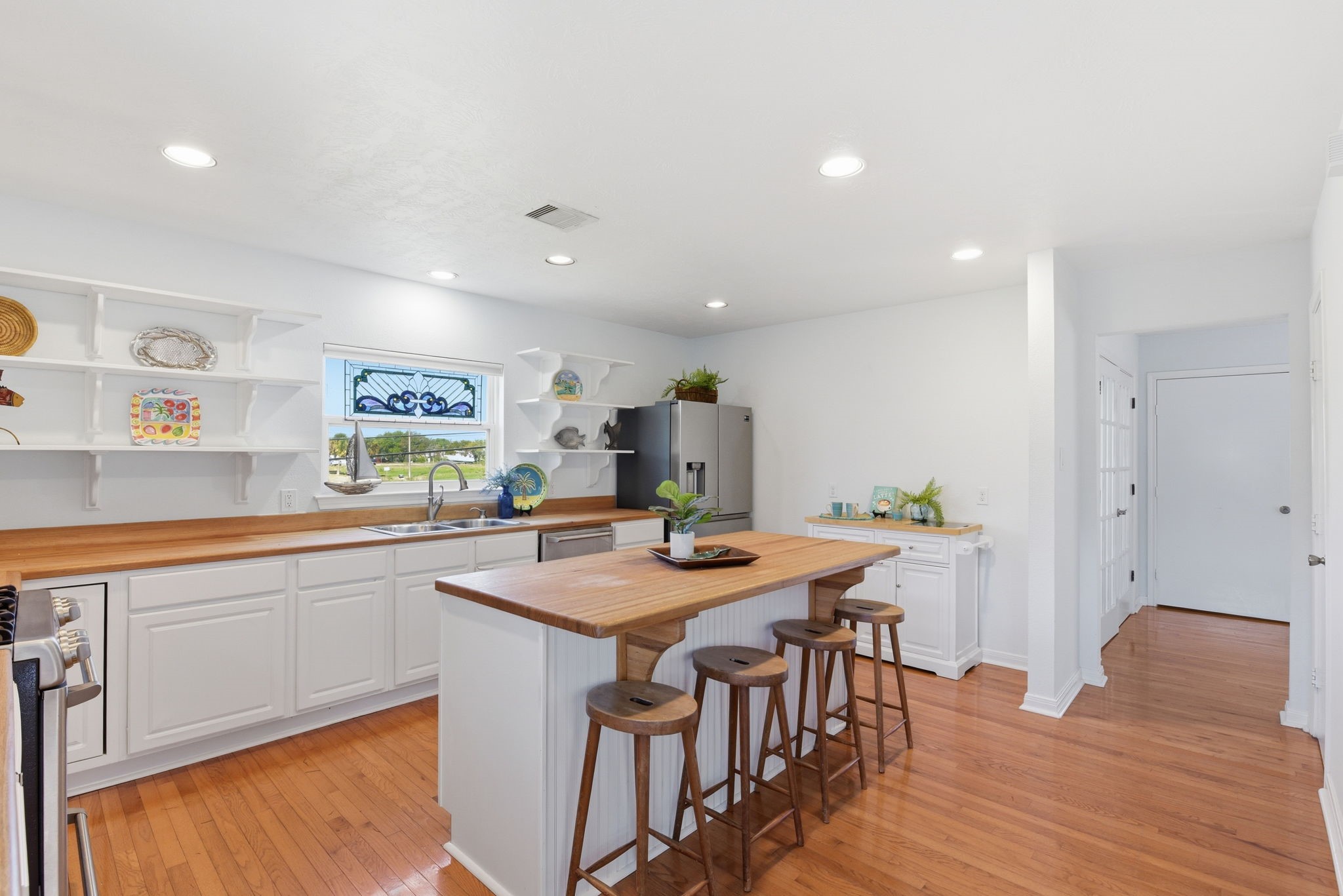 180 Grove Road Kemah, TX 77565 - Photo 11 of 30 This inviting kitchen combines ample storage with elegant display shelves, perfect for showcasing your collectibles in style.