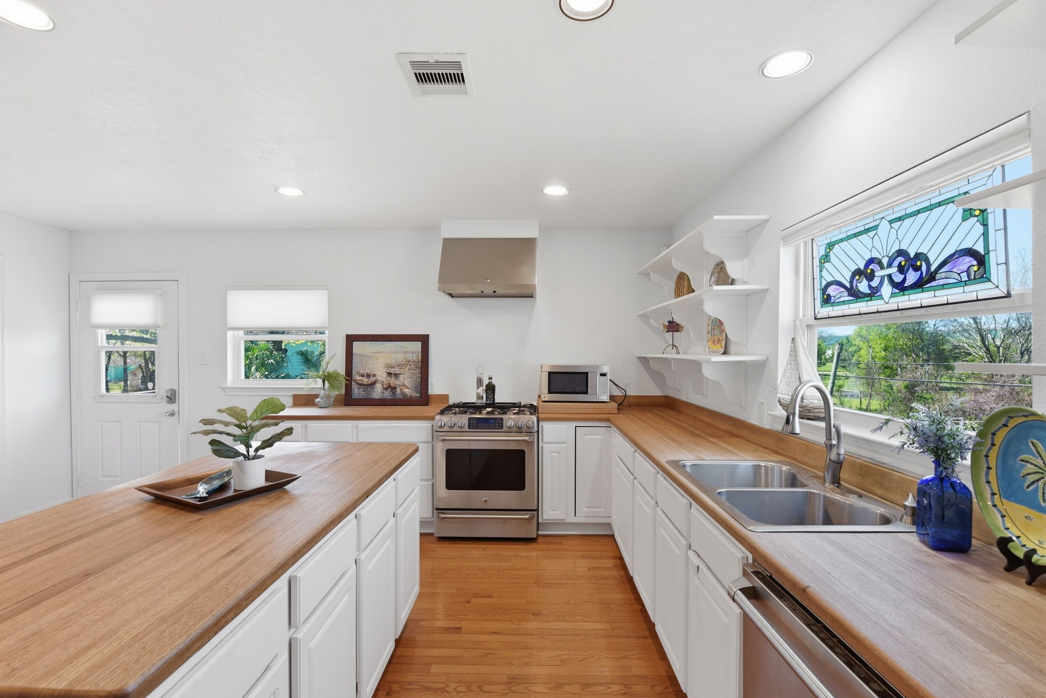 180 Grove Road Kemah, TX 77565 - Photo 12 of 30 This kitchen offers a warm and inviting space with its sleek gas range, convenient double sinks, and charming coffee bar, perfect for culinary enthusiasts and coffee lovers alike.
