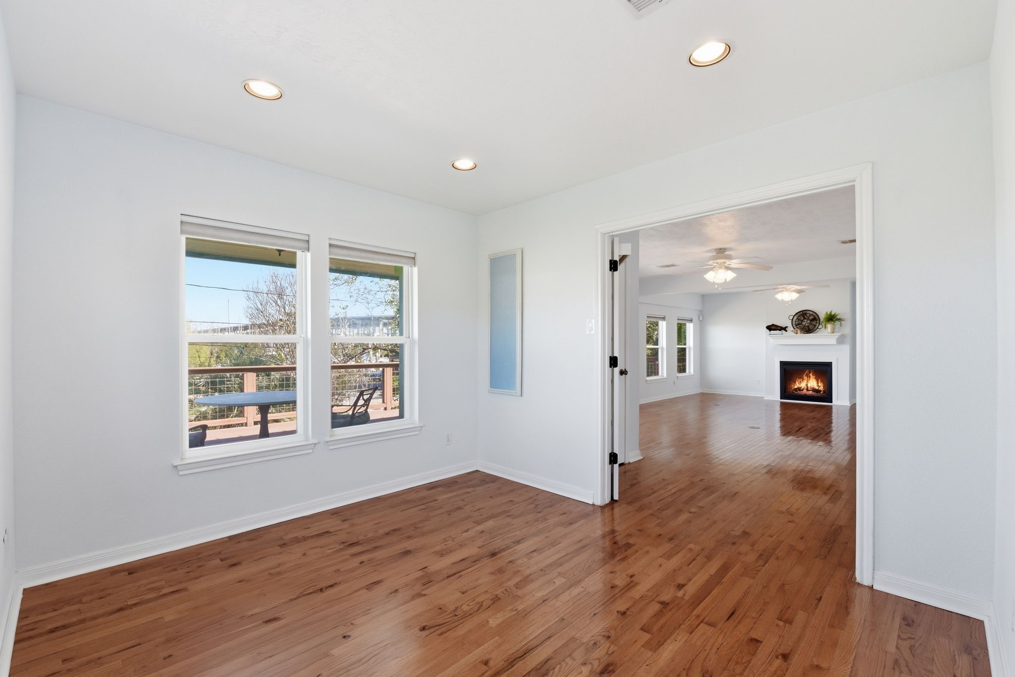 180 Grove Road Kemah, TX 77565 - Photo 14 of 30 This bright, unstaged study offers a blank canvas for creativity and productivity, seamlessly connecting to a cozy living area with a fireplace, perfect for both work and relaxation.