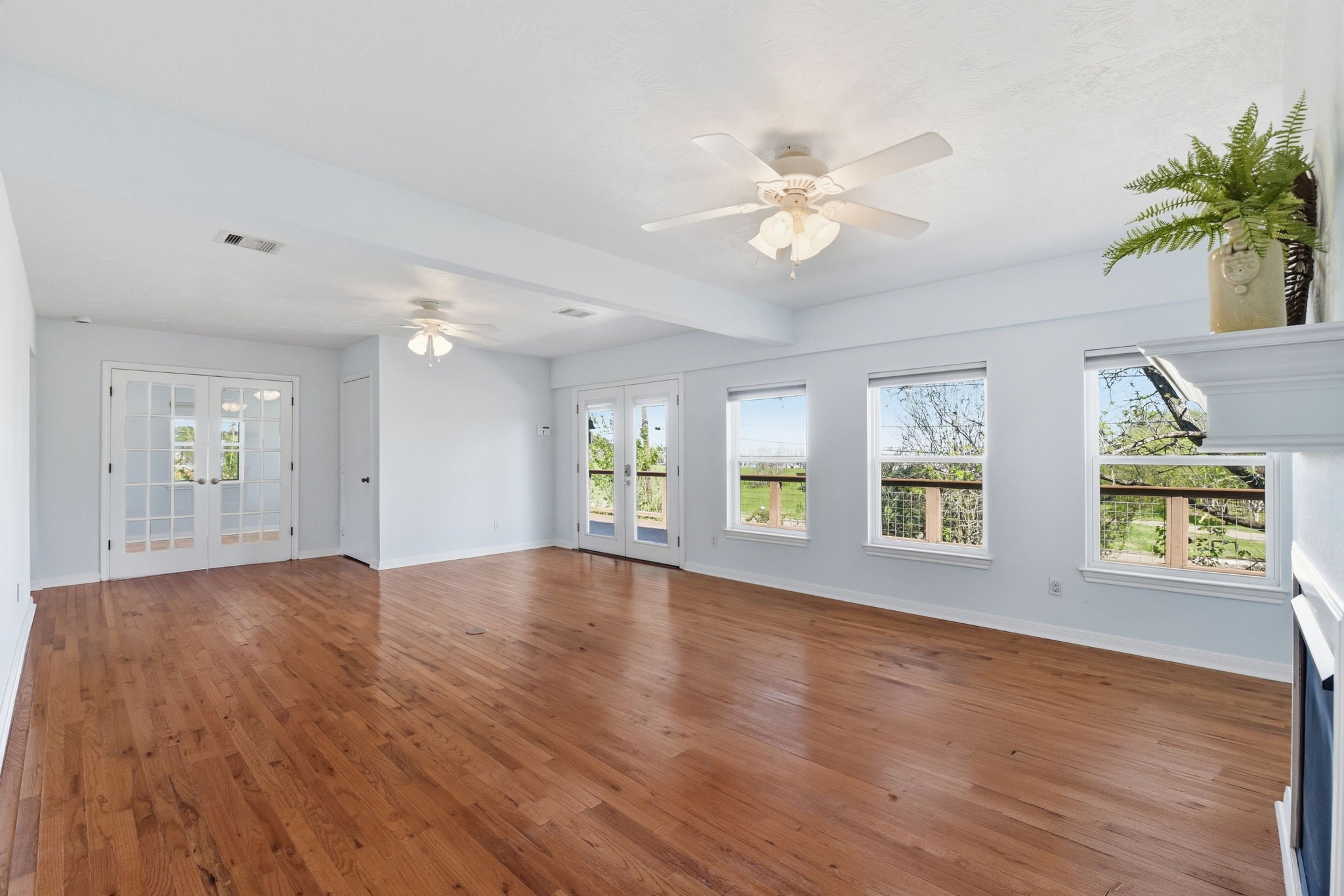 180 Grove Road Kemah, TX 77565 - Photo 8 of 30 This spacious living room seamlessly flows into a cozy study through elegant double French doors, creating a perfect blend of style and functionality.